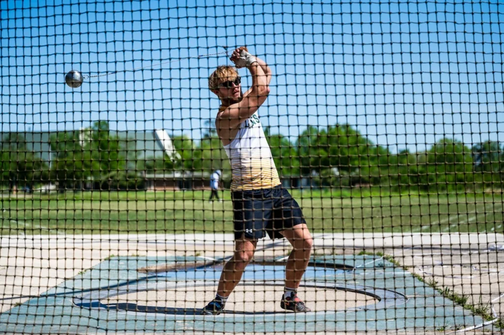 NCAA atletikatlet konkurrerer i hammerkast.