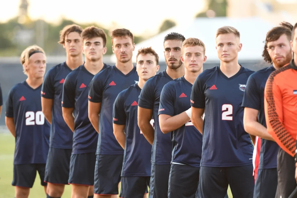 Collegefootballhold synger nationalsangen.